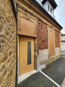 a yellow door on the side of a brick building at Appartement de Thomas in Charleville-Mézières