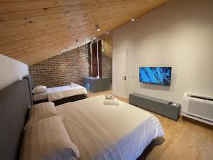 a bedroom with two beds and a flat screen tv at Bujtina Apsus in Berat