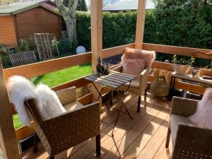 un patio con sillas y una mesa en un porche en CARLA AM STRAND, en Garrel