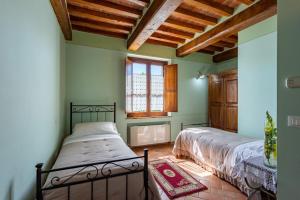 2 Betten in einem Zimmer mit grünen Wänden und Holzdecken in der Unterkunft Corte Delle Stelle in Cortona + 20 Fotos
