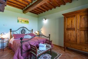 a bedroom with a pink bed and a wooden cabinet at Corte Delle Stelle in Cortona