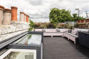 a rooftop garden with benches and a reflecting pool at Stunning Townhouse with large roof terrace in London