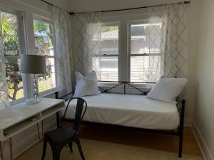 um quarto com uma cama, uma cadeira e uma janela em Southern Charm in Lakeland em Lakeland