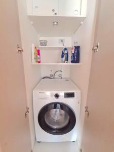 - Lavadora y secadora en una habitación pequeña en Depto nuevo Full equipado - Estacionamiento - Plaza Egaña, Ñuñoa, en Santiago