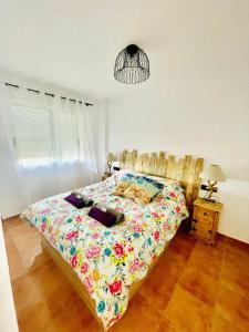 a bedroom with a bed with a colorful comforter at Apartament Bella Vista in Los Nietos