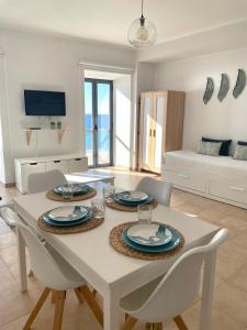 a dining room with a white table and chairs at A Casa Dos Amigos in Sesimbra