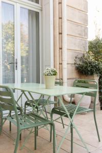 un tavolo verde e sedie su un patio di Maison Douce Arles a Arles