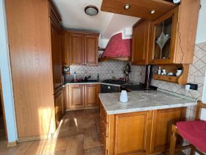 cocina con armarios de madera y encimera de granito en Mountain Home, en Valle di Cadore