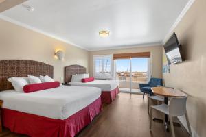 um quarto de hotel com duas camas e uma televisão em Beach Street Inn and Suites em Santa Cruz