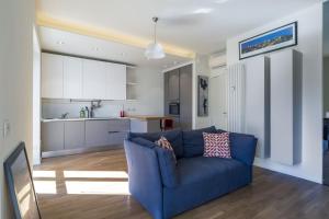 sala de estar con sofá azul y cocina en Easylife - Accogliente appartamento in Bocconi en Milán