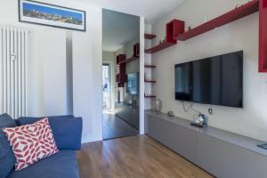 un soggiorno con divano blu e TV a schermo piatto di Easylife - Accogliente appartamento in Bocconi a Milano