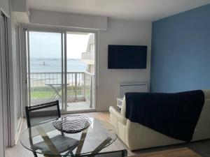 salon z kanapą i szklanym stołem w obiekcie Appt T2 vue imprenable sur Mer w mieście Saint-Quay-Portrieux