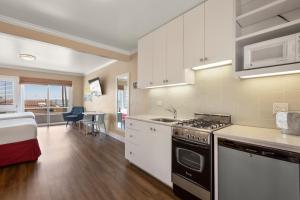 uma cozinha com armários brancos e um forno com placa de fogão em Beach Street Inn and Suites em Santa Cruz