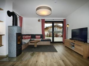a living room with a fireplace and a television at Chalet Alpenzauber, Inzell in Inzell