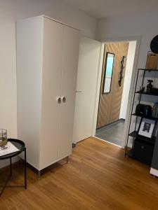 uma sala de estar com um armário branco e uma mesa em -Bella Casa- Central Studio Apartment em Fürth