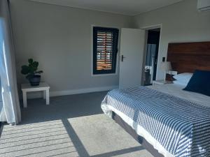 a bedroom with a bed and a window at Kwikstertjie in Hermanus