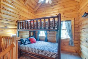 a bedroom with a bunk bed in a log cabin at Lovely Gatlinburg Cabin with Private Hot Tub! in Gatlinburg