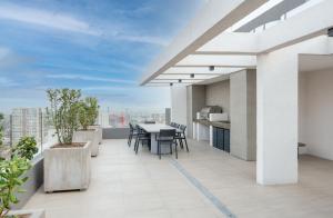 un balcone con tavolo e sedie su un edificio di Depto nuevo Full equipado - Estacionamiento - Plaza Egaña, Ñuñoa a Santiago