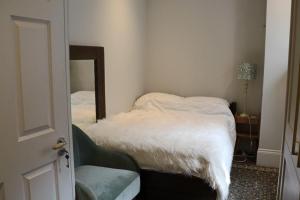 ロンドンにあるBeautiful maisonnette flat in Islingtonの鏡とベッド付きの小さな部屋