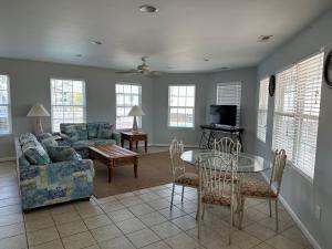 sala de estar con sofá, mesa y sillas en Pirates Cove, en Carolina Beach