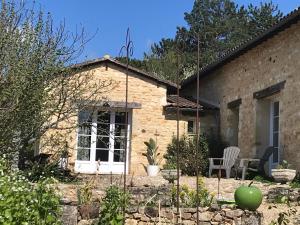 a stone house with a garden and a patio at Domaine la Borniotte in Saint-Alvère