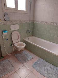 uma casa de banho com um WC e uma banheira em شقة فندقية no Cairo