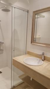y baño con lavabo y ducha acristalada. en Apartamentos Turisticos Arosa Ogrove, en O Grove