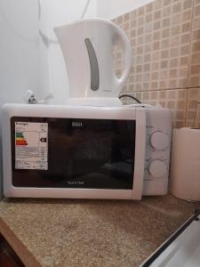 a white microwave sitting on top of a counter at Alojamiento Belen Catamarca in Belén