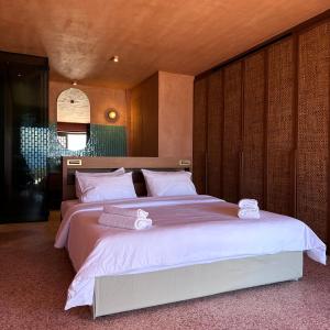 メガニシ島にあるMirazurのベッドルーム1室(ベッド2台、白いシーツ、タオル付)