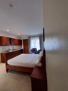 pokój hotelowy z łóżkiem i kuchnią w obiekcie Le Cottage Mbale w mieście Mbale
