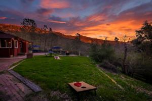 a field with a table in the grass with a sunset at Sierra Vista Lookout Lodge with Creek, Waterfall and Waterholes, minutes from Bass Lake and Yosemite South Gate in North Fork
