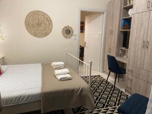 a bedroom with a bed and a table and a chair at Zoi's central home in Volos