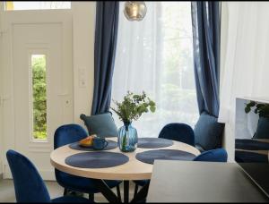 a dining room with a table and blue chairs at Blue Bird Citadel Apartment in Budapest