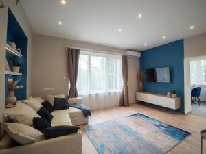 a living room with a white couch and blue walls at Blue Bird Citadel Apartment in Budapest