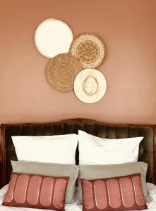 a bed with white pillows and straw hats on the wall at Studio 1 du SPA Célinie in Warcq