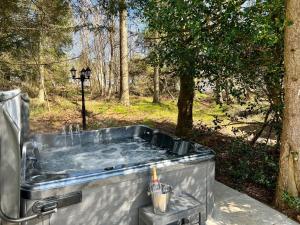 a hot tub in the middle of a forest at Leaf Lane Lodge in Newton on the Moor