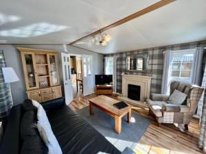 a living room with a couch and a fireplace at Leaf Lane Lodge in Newton on the Moor
