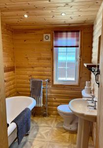 a bathroom with a tub and a toilet and a sink at Eagle Lodge in Newton on the Moor +8 photos