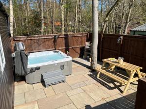 a backyard with a hot tub and a picnic table at Eagle Lodge in Newton on the Moor