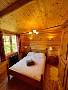 a bedroom with a bed in a wooden cabin at Eagle Lodge in Newton on the Moor