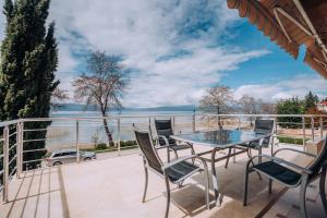 balcón con mesa, sillas y vistas al agua en VILLA AFRODITA LAKE SIDE en Lagadin