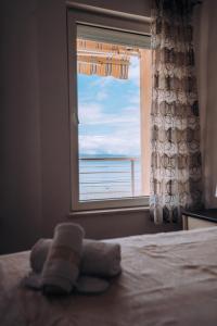 een slaapkamer met een raam met uitzicht op de oceaan bij VILLA AFRODITA LAKE SIDE in Lagadin