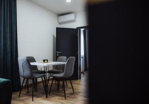 ein Esszimmer mit einem weißen Tisch und Stühlen in der Unterkunft Modern Apartment 3 in Brčko