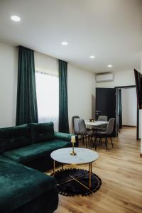 uma sala de estar com um sofá verde e uma mesa em Modern Apartment 3 em Brcko