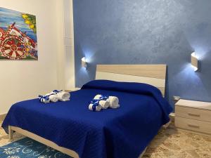 Un dormitorio con una cama azul con toallas. en Casa Sciacca, en Marsala