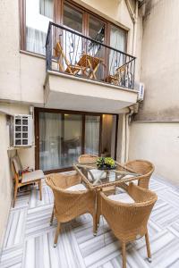 a patio with wicker chairs and a table on a balcony at Calanthe Residence in Istanbul