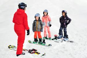 a group of children standing in the snow on skis at Alpine Hotel by SnowWorld in Landgraaf