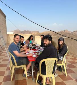 a group of people sitting at a table eating food at Hustle's look in Wadi Musa