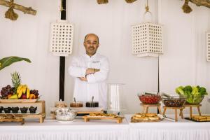 mężczyzna stojący przed stołem z jedzeniem w obiekcie Antonina Hotel w mieście Agia Anna (Naxos)