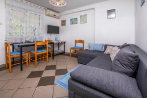ein Wohnzimmer mit einem Sofa und einem Tisch in der Unterkunft Apartments Sopic in Rogoznica